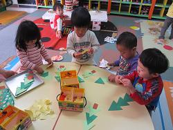 折り紙で遊ぶ乳児クラスの子どもたち