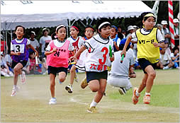 リレー競争で走る子供たちの画像