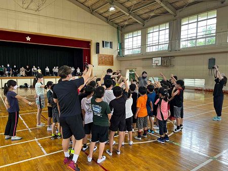 ベルテックス静岡の選手と子供たちが中央に集まり腕を上げている写真